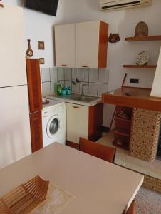 a kitchen with a sink and a washing machine at La collinetta in Casa Regnano