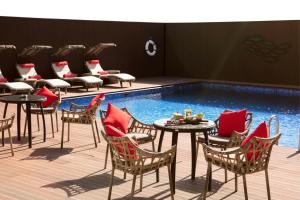 a group of chairs and tables next to a pool at Rosh Olaya in Riyadh