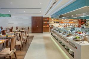 a restaurant with a buffet line with tables and chairs at Rosh Olaya in Riyadh