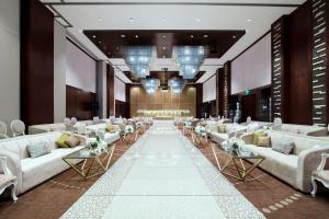 a large room with white couches and a aisle with flowers at Rosh Olaya in Riyadh +172 photos