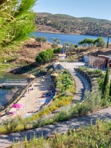 a group of people laying on a beach next to a river at Blue Dragon River House in Odeleite