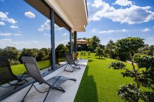 a patio with chairs and an umbrella and grass at Apartma Belvi in Brežice