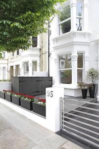 a white house with flowers on the side of it at Holiday Lets London 4 in London