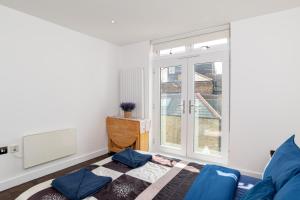 a living room with a blue couch and a window at Holiday Lets London 4 in London