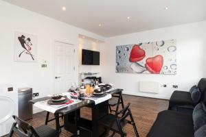 a kitchen and living room with a table and chairs at Holiday Lets London 4 in London