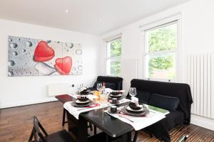a dining room with a table and a couch at Holiday Lets London 4 in London