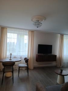 a living room with a tv and a table and chairs at Svečių namai Lanko g. in Klaipėda