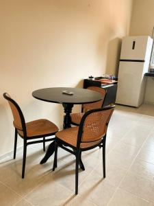 a table and chairs in a kitchen with a refrigerator at Hospedaria Terra da Opala in Pedro II