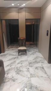 a chair in a room with a marble floor at شقق المحمدية - Al Mohammadia apartment in Jeddah