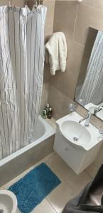 a bathroom with a sink and a shower curtain at Ventanas A LA CIUDAD in Mar del Plata