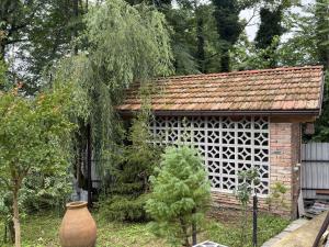a small building with a window in a garden at Okatse Lodge in Gordi