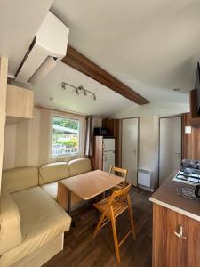a living room with a couch and a table at Mobile-home in Ivry-la-Bataille