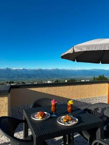 a table with plates of food and an umbrella at Horizont Boutique Hotel in Telavi