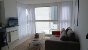 a living room with a couch and a large window at Ventanas A LA CIUDAD in Mar del Plata