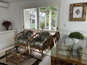 a living room with two chairs and a glass table at San Clemente Residence in Gramado