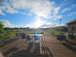 a patio with a table and chairs on a deck at Solheim Guesthouse Andøy in Dverberg