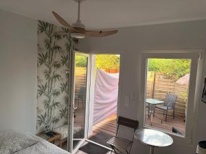 a room with a patio with a table and chairs at les aulnes de sanguinet lac et piste cyclable ,5mn à pied in Sanguinet