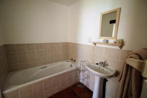 a bathroom with a bath tub and a sink at Baywatch Paternoster -The Villa in Paternoster +18 photos