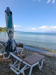 two lounge chairs and an umbrella on a beach at Gardenhouse2 in Mëmëlisht +21 photos