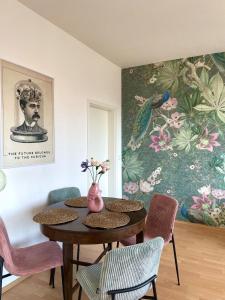 a dining room with a table with chairs and a painting at Panoramablick am Theaterplatz stilvolle Wohnung in Chemnitz +9 photos