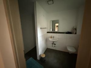 a bathroom with a toilet and a sink and a mirror at Ferienwohnung26 in Blankenfelde