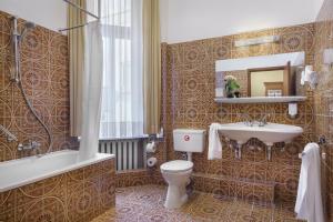 a bathroom with a toilet and a sink and a tub at Garner Hotel Hamburg St. Georg by IHG in Hamburg +183 photos