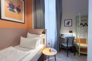 a hotel room with a bed and a desk and a chair at Garner Hotel Hamburg St. Georg by IHG in Hamburg