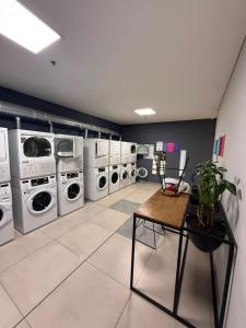 a laundry room with several washing machines and a table at Fly At Home Bogotá in Bogotá +8 photos