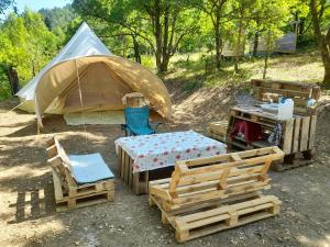 a tent and chairs and a table and a table and chairs at Glamping en Tente Yourte in Ispagnac