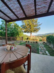a wooden table sitting under a wooden pergola at Domus Mazzoni in Capannori