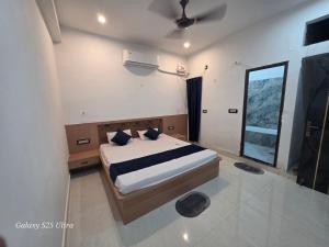 a bedroom with a bed and a ceiling fan at Hotel SunFort in Rājgīr