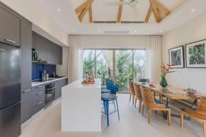 a kitchen and dining room with a table and chairs at Luxury 3-Bedroom private pool villa Trichada Breeze in Phuket