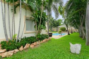 a yard with palm trees and a swimming pool at Luxury Pool Villa 3BR 6-8 persons in Nong Prue