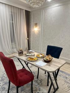 a dining room table with plates of food on it at Royal hostel in Osh