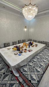 a table with plates of food on it in a room at Royal hostel in Osh