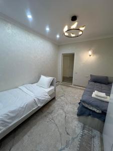 a bedroom with two beds and a ceiling fan at Royal hostel in Osh +6 photos