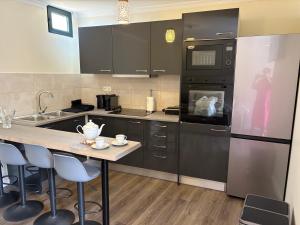 a kitchen with black appliances and a table with chairs at Casa Barros in Campanário