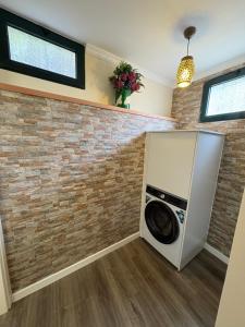 a washer and dryer in a room with a brick wall at Casa Barros in Campanário