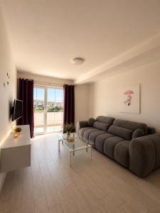 a large living room with a couch and a television at Apartments Marina in Lopar