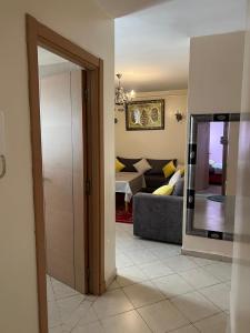 a living room with a couch and a mirror at Appartement Pour Vacances in Agadir