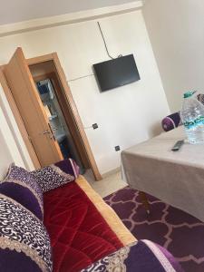 a room with a bed and a television on the wall at Appartement Pour Vacances in Agadir