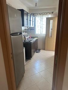 a kitchen with a refrigerator and a tile floor at Appartement Pour Vacances in Agadir