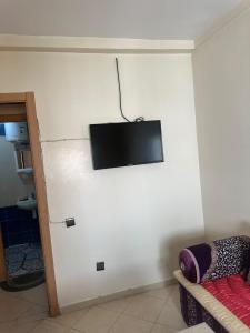 a living room with a tv on a white wall at Appartement Pour Vacances in Agadir +9 photos