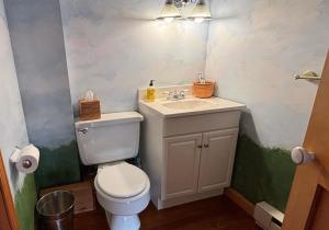 a bathroom with a white toilet and a sink at Mount Hope Bay Cottage in Fall River +12 photos