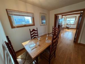a dining room with a wooden table and chairs at Mount Hope Bay Cottage in Fall River