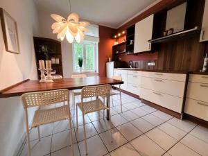 a kitchen with a wooden table and chairs in it at Ferienwohnung Ostseeglück in der Villa Marie in Kühlungsborn