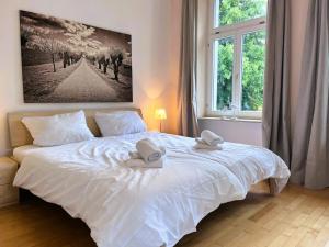 a bedroom with a white bed with two towels on it at Ferienwohnung Ostseeglück in der Villa Marie in Kühlungsborn