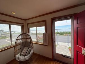 a room with a swing in front of windows at Mount Hope Bay Cottage in Fall River