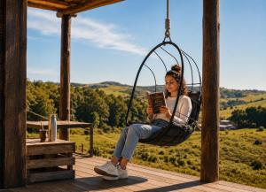 a woman sitting in a swing reading a book at Valle de la Luna in Tandil