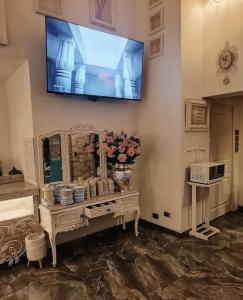 a living room with a television on a wall at Hotel Vila Santa in Lima